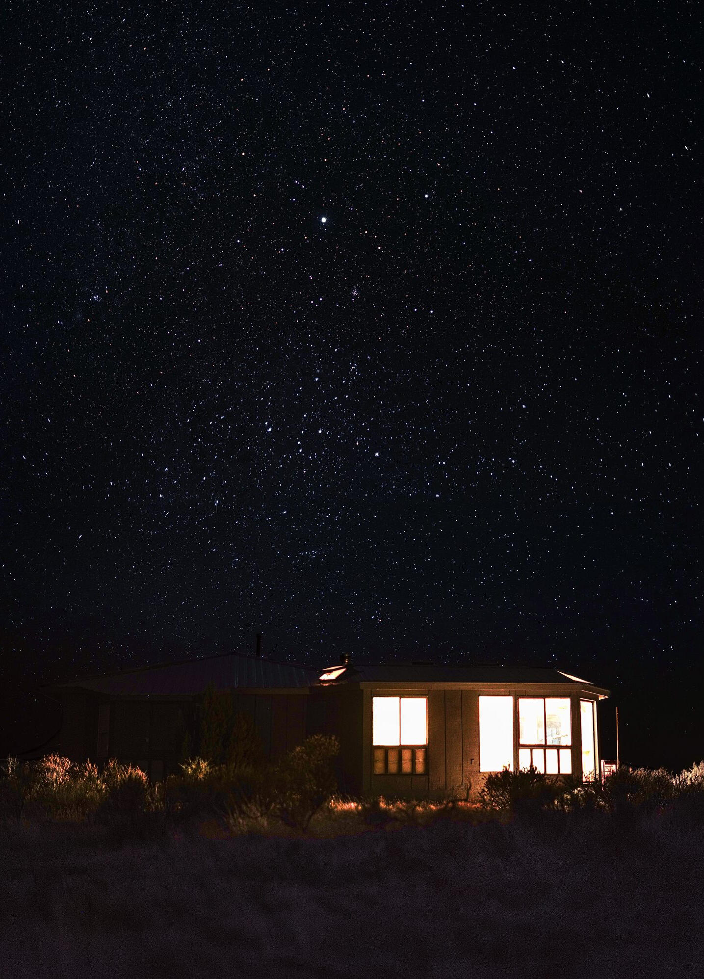Untitled Cabin windows under a starry Northern Arizona sky